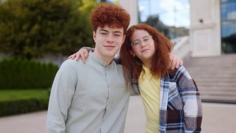 Stylish redhead teens posing outdoors and looking naturally at the camera Stock Footage 320768780