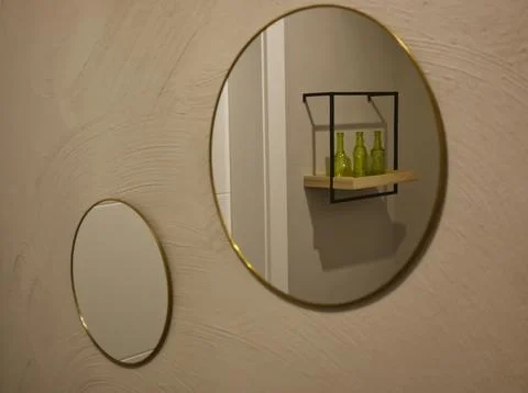 Stylish Round Mirrors with Gold Frames and Green Bottles 写真素材