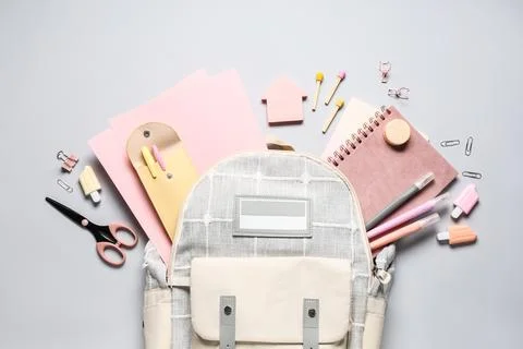Stylish school backpack and different stationery on grey background Stock Photos