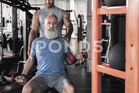 Stylish senior male spending time in athletic center with trainer Stock Photos