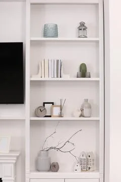 Stylish shelves with different decor elements in room. Interior design Stock Photos