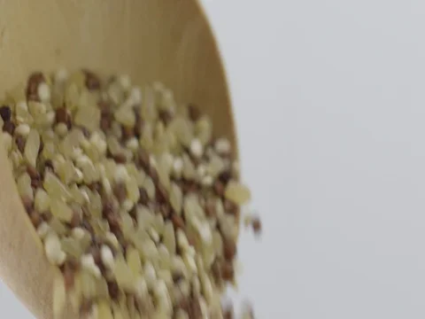 Stylish slow motion mixed grains falling off a wooden spoon Stock Footage 81338013
