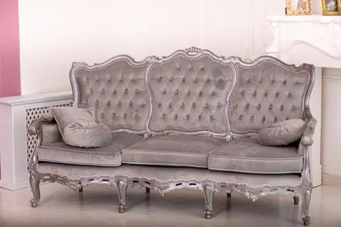 Stylish studio Interior. Beautiful gray sofa in classical style on a backgrou Stock Photos