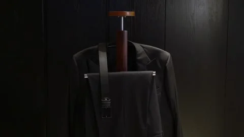 A Stylish Suit Hung on a Hanger Set Against a Distinct Dark Background, Stock Footage 291006178