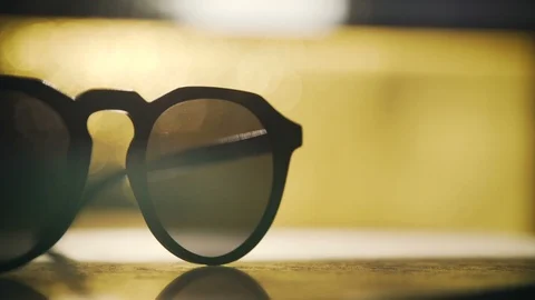Stylish sun glasses on a table in sunset light Video stock 102727893