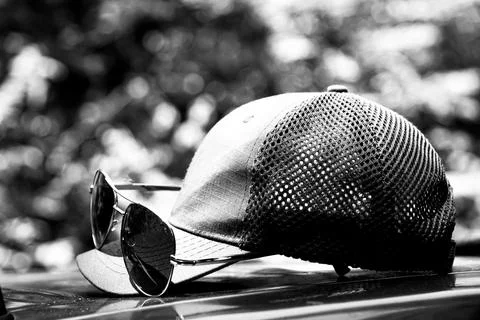Stylish sunglasses on a gray cap visor, summer sunglasses composition Stock Photos