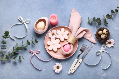Stylish table setting with sweet cookies, Easter eggs, beautiful flowers and  Stock Photos