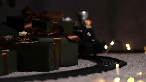 Stylish toy train rides reverse under Christmas tree with many gift boxes Stock-Footage 165947918