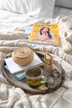 Stylish tray with different interior elements and tea on bed 스톡 사진