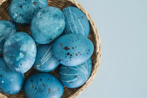 Stylish trending Easter eggs in blue tones in a wicker basket close-up on a Stock Photos