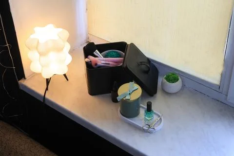 Stylish vanity setup with makeup brushes, nail polish, and decorative lamp Stock Photos