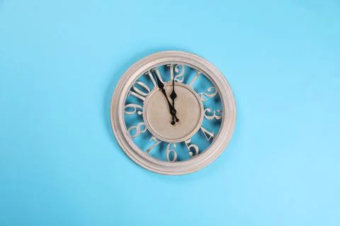 Stylish wall clock showing five minutes until midnight on turquoise backgroun Stock Photos