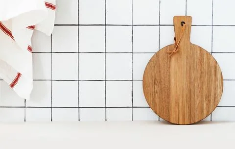Stylish white kitchen background with kitchen towel and wooden cutting boar.. Stock Photos