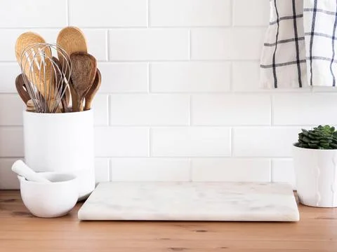 Stylish white kitchen background with kitchen utensils standing on wood cou.. Stock Photos