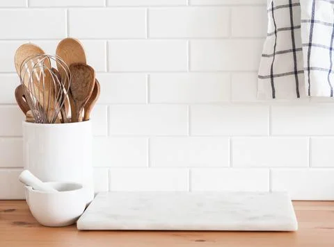 Stylish white kitchen background with kitchen utensils standing on wood cou.. Stock Photos