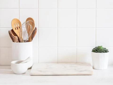 Stylish white kitchen background with kitchen utensils standing on wood cou.. Stock Photos
