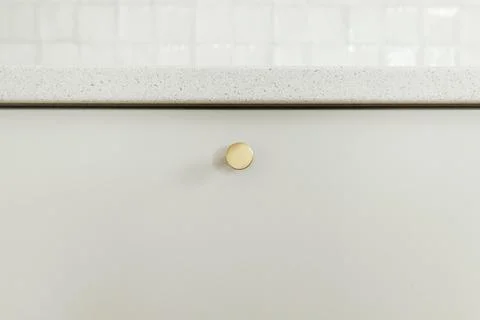 Stylish white kitchen cabinets with brass knobs and granite countertop clos.. Stock Photos