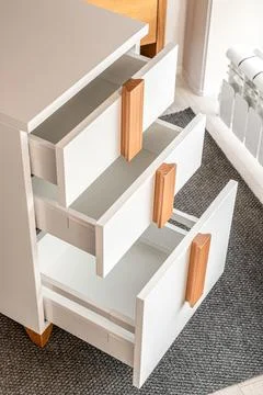 Stylish white office commode with open drawers closeup 写真素材