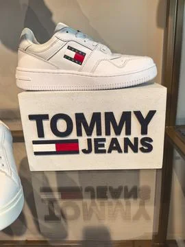 Stylish white sneakers on display with bold branding at a fashion store Stock Photos