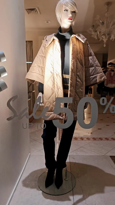 Stylish winter clothes on a mannequin behind a glass door featuring a fifty Stock Footage 329259789