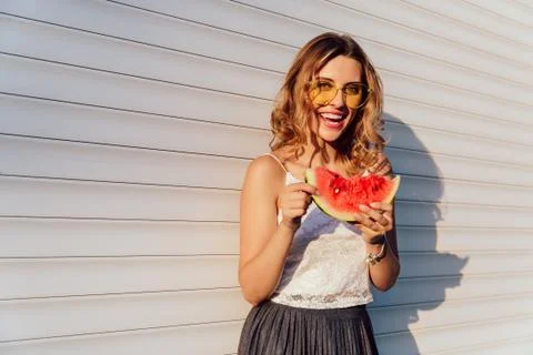 Stylish woman eating a watermelon, outdoors. Stock Photos