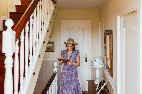 Stylish woman smiling while using a digital tablet standing at home. Foto stock