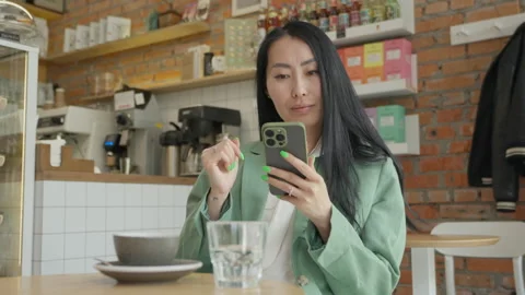 Stylish Woman Using Smartphone While Sitting With Coffee In Modern Cozy Cafe Stock-Footage 318986274