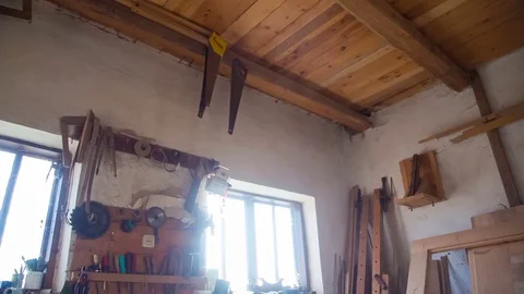 A stylish woodworking wizard uses a hand-held tool. Wall stand with joiner with Stock Footage 84516559