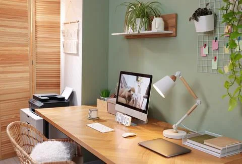 Stylish workplace with computer, laptop and lamp near olive wall at home Stock Photos