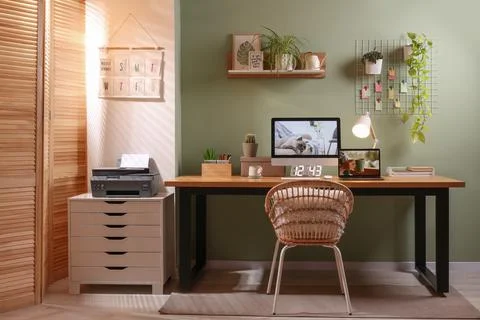 Stylish workplace with computer, laptop and lamp near olive wall at home Stock Photos