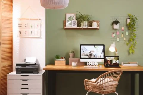 Stylish workplace with computer, laptop and lamp near olive wall at home Stock Photos