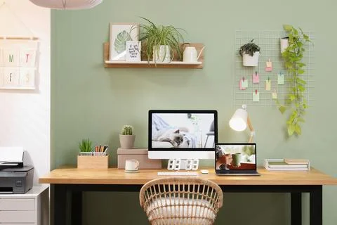 Stylish workplace with computer, laptop and lamp near olive wall at home Stock Photos