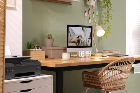 Stylish workplace with computer, laptop and lamp near olive wall at home 스톡 사진