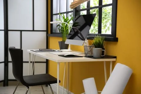 Stylish workplace with computer near window at home office. Space for text Stock Photos