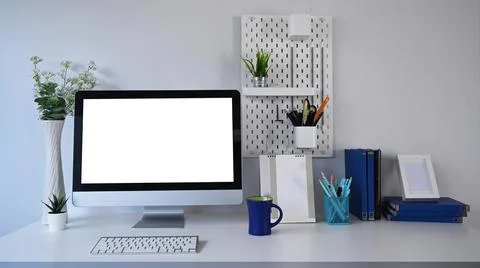 Stylish workplace with mock up computer and office supplies on white table. Stock Photos