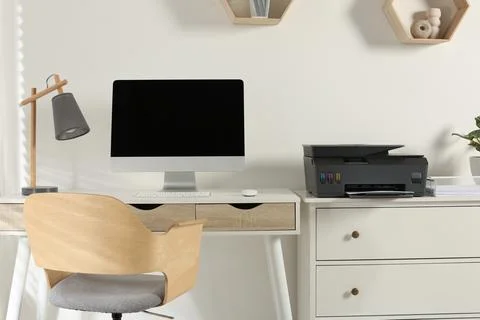 Stylish workplace with modern computer, printer and lamp Stock Photos