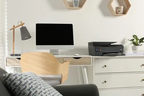 Stylish workplace with modern computer, printer and lamp Stock Photos