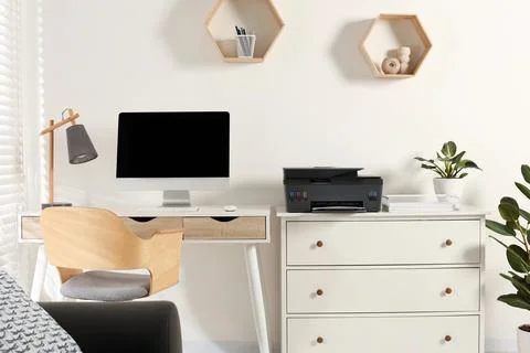Stylish workplace with modern computer, printer and lamp Stock Photos