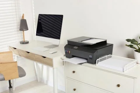 Stylish workplace with modern computer, printer and lamp Stock Photos
