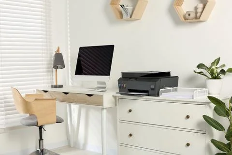 Stylish workplace with modern computer, printer and lamp 스톡 사진