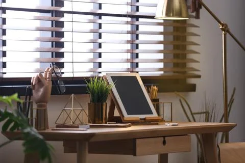 Stylish workplace with modern tablet on table at window. Ideas for interior d Stock Photos