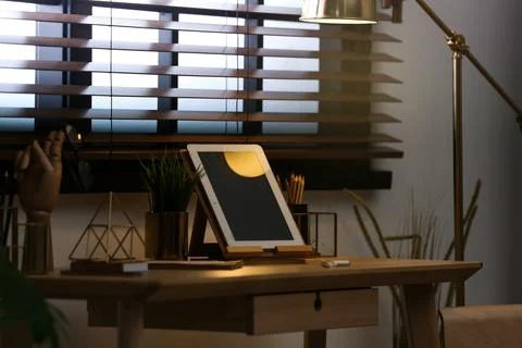 Stylish workplace with modern tablet on table at window. Ideas for interior d Stock Photos