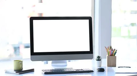 Stylish workstation with computer, coffee cup and office supplies on white ta Stock Photos