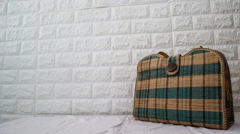 Stylish woven handbag with a checkered pattern in green and beige against a.. Foto stock