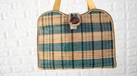 Stylish woven handbag with a checkered pattern in green and beige against a.. Stock Photos