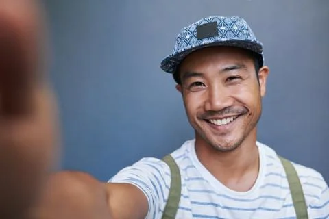 Stylish young Asian man taking a selfie outside Stock Photos