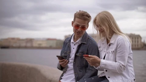 Stylish young beautiful couple of blondes guy and girl are typing messages Stock Footage 114455853