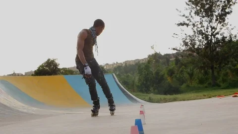 Stylish young boy riding roller skates in slow motion in a park. Stock Footage 110841440