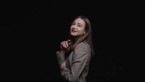A stylish young brunette in a jacket feels happy, smiling cheerfully and posing  Stock Footage 195611213