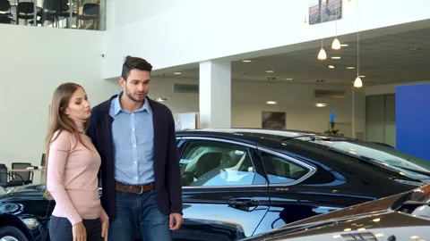 Stylish young couple exploring car options at the dealership Vídeos de archivo 311894382